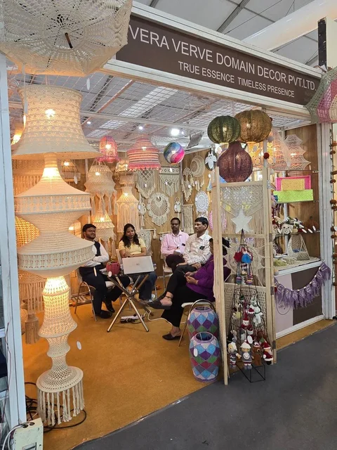 The Vera Verve team seated in the stall at IHGF Delhi Fair Spring 2025, surrounded by macramé and crochet lighting.