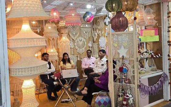 The Vera Verve team seated in the stall at IHGF Delhi Fair Spring 2025, surrounded by macramé and crochet lighting.