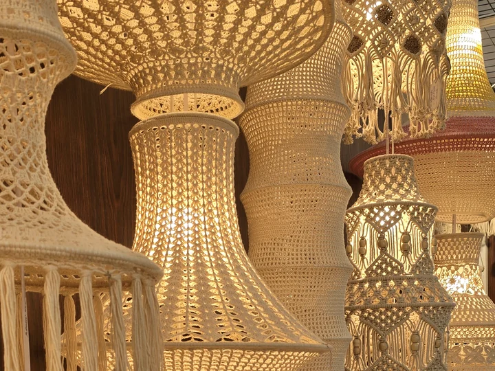 Cream crochet and macramé pendant lamps glowing together at our stall, IHGF Delhi Fair Autumn 2025.